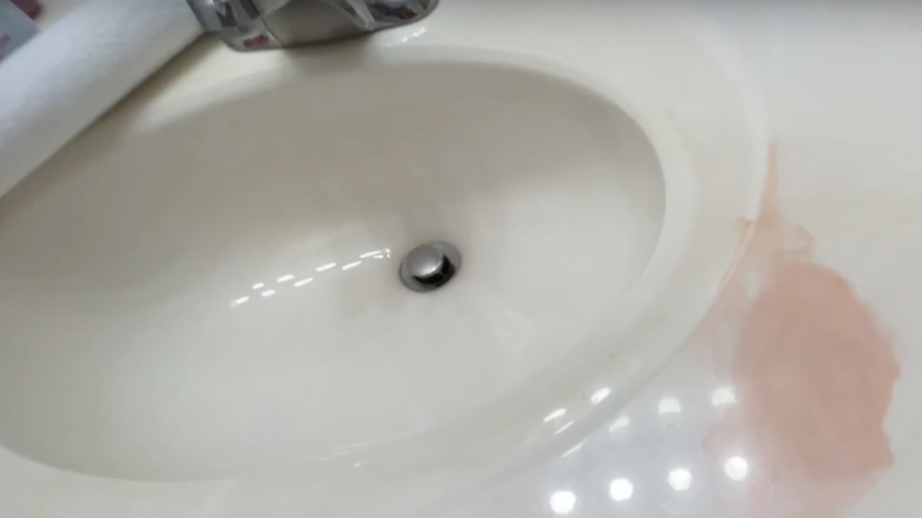 a sink with a red hair dye stain on it