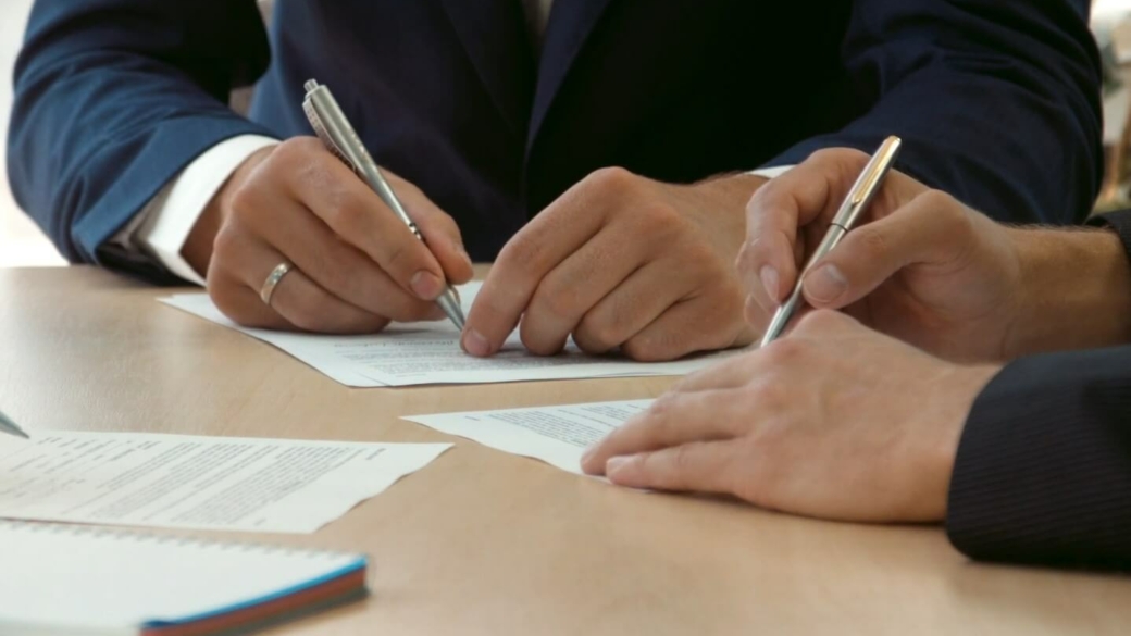 Multiple people signing a contract