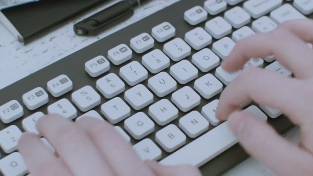 hands typing on a white keyboard